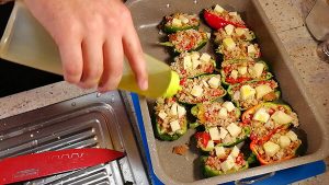 Peperoni ripieni disposti nella teglia da forno con un filo d'olio, pronti per la cottura a 200 gradi