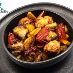 Padellaccia beneventana in padella con pezzi di maiale fritto, patate dorate e peperoni sott'aceto