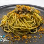 Spaghetti con sarde, finocchietto selvatico e pangrattato tostato serviti in un piatto fondo